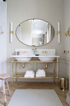 a bathroom with two sinks and a large round mirror above the sink in front of it