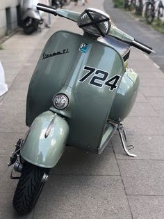 a green scooter is parked on the sidewalk