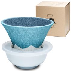 a blue and white bowl sitting on top of a plate next to a cardboard box