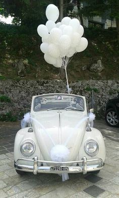 an old car with balloons attached to it