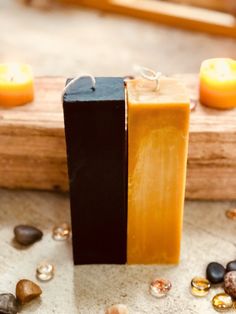 two bars of soap sitting on top of each other next to some rocks and candles