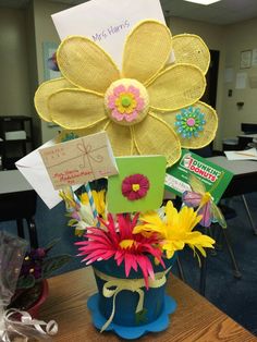 a flower pot is decorated with cards and flowers