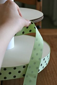 a person is using a ribbon to make a polka dot design on a table top