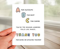 a person holding up a card with the words thank you for awesome teacher on it