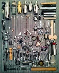 an assortment of kitchen utensils are displayed on a gray tableclothed surface