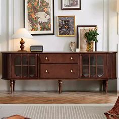 a living room with pictures on the wall and an entertainment center in front of it