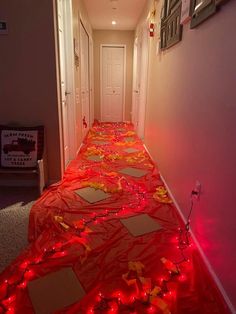 the hallway is decorated with red lights and paper plates on the floor, along with other decorations