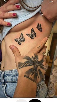 a woman's stomach with butterflies on it and her hand in front of her belly