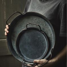 a person holding a large metal plate in their hands