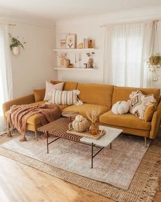 a living room filled with furniture and pillows on top of a carpeted floor next to a window