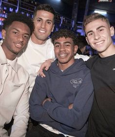 four young men are posing for the camera in front of a crowd at an event