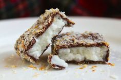 two pieces of chocolate and coconut covered dessert on a white plate with sprinkles