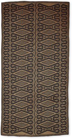 an old black and brown rug with wavy lines on the bottom, and two rows of circles