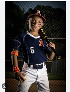 a young boy holding a baseball bat on top of a field at night with his face painted