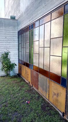 an old building with stained glass windows on the outside and grass in front of it