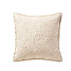 a white pillow with an intricate design on the front and back, sitting on a white surface