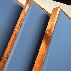 three pieces of wood sitting next to each other on top of a blue sheeted paper