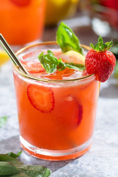 a drink with strawberries and mint garnish on the rim