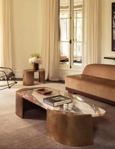 a living room filled with furniture next to a window and a painting on the wall