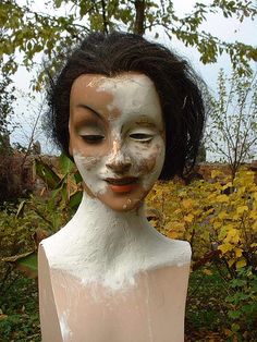 a woman's face is covered in white paint