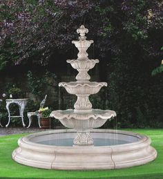 a water fountain sitting on top of a lush green field