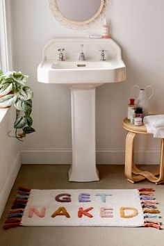 a bathroom with a sink, rug and mirror