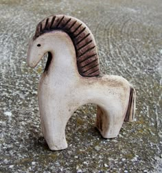 a small ceramic horse is sitting on the ground