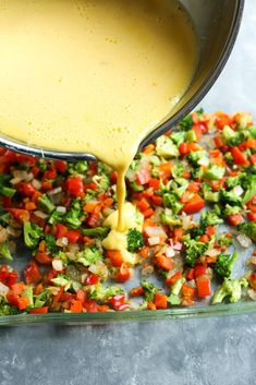 broccoli, carrots and other vegetables being poured into a pan with sauce