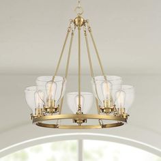 a chandelier with five glass shades hanging from it's golden metal frame