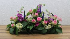 a bunch of flowers sitting on top of a wooden table