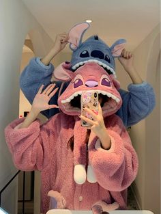 a woman taking a selfie in front of a mirror wearing a pink dragon costume