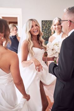 a woman in a wedding dress standing next to a man