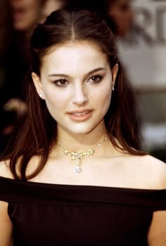 a woman in a black dress posing for the camera with her hand on her hip