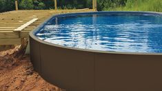 an above ground swimming pool surrounded by sand and wood planks with the words, exclusive wood grain paneling 2 color options available