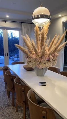 a table with chairs and a vase filled with flowers