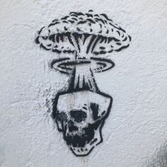 graffiti on the side of a building with a skull in it's head and an exploding mushroom coming out of its mouth