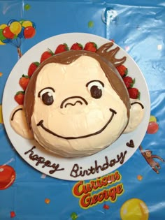 a birthday cake that looks like a monkey with strawberries on his head and the words happy birthday curious george