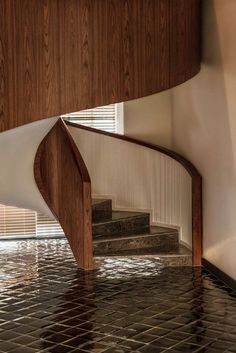 a spiral staircase in the middle of a flooded room with tile flooring and wooden walls