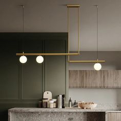 a kitchen with marble counter tops and gold fixtures on the ceiling, along with hanging lights