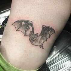 a small bat tattoo on the leg