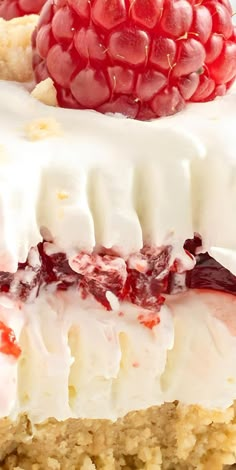 there is a piece of cake with raspberries on top and white frosting