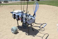 a cart with fishing rods attached to it in the sand