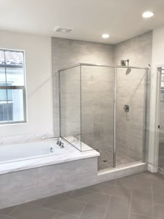 a bathroom with a walk in shower next to a bath tub