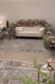 a living room filled with lots of furniture and flowers on top of carpeted flooring