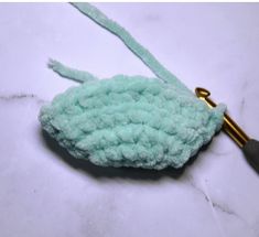 a crocheted hook is shown on a marble surface