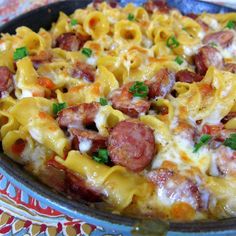 a pan filled with pasta and sausage covered in cheese