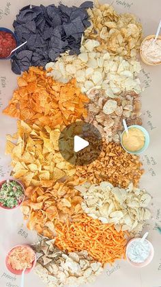 a table topped with lots of different types of chips and dips on top of it