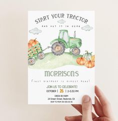 a person holding up a card with a tractor and pumpkins on it