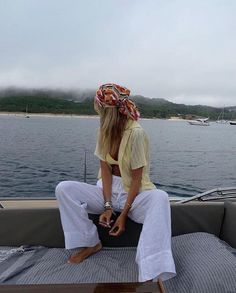 a woman sitting on the back of a boat