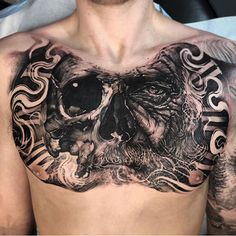 a man's chest with a skull tattoo on it